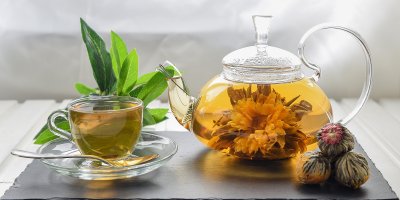 Šálek a konvička s kvetoucím čajem