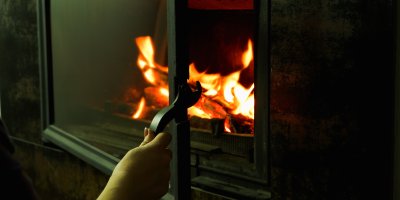 Ženská ruka otevírající krbová dvířka