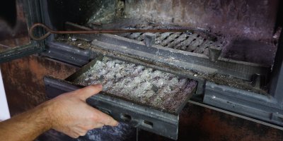 Muž vyndává výměník popela v krbu