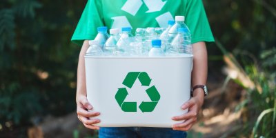 Člověk drží krabici plnou PET lahví