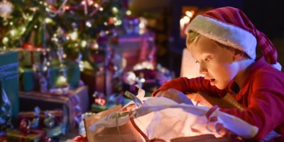 Chlapec se dívá na obsah vánočního dárku