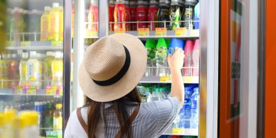 Žena si vybírá nealkoholický nápoj z regálu v obchodě