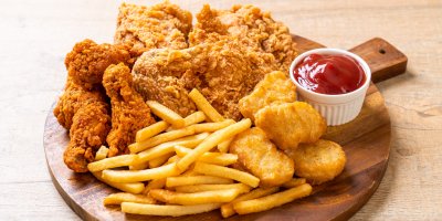 Smažené kuřecí nugetky a kousky s hranolky a kečupem