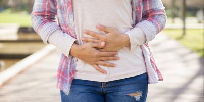 Žena držící se za břicho