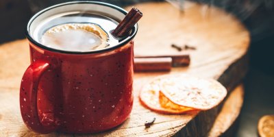 Svařák v plechovém hrnku se skořicí a plátkem pomeranče