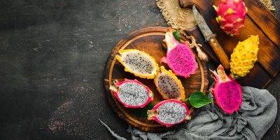 Různé druhy dračího ovoce na dřevěném podnosu s nožem a látkou