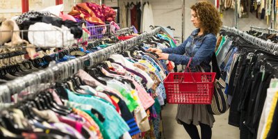 Žena si v second handu vybírá oblečení