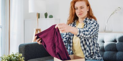 Žena si rozbaluje tričko a tváří se zklamaně