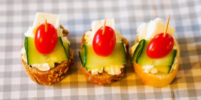 Tři jednohubky z celozrnné bagety s okurkou, rajčátkem a sýrem