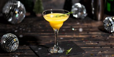 Mimosa ve vysoké sklenici na dřevěném stole