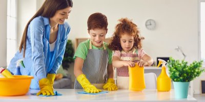 Žena a dvě děti uklízí na stole