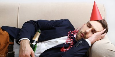 Muž leží na gauči a spí