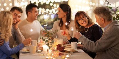 Šest lidí sedí u stolu a drží prskavky