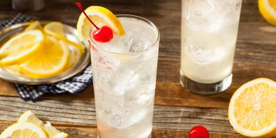 Sklenice s koktejlem ozdobená pomerančem a třešní