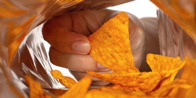 Ruka sahající do sáčku s chipsy