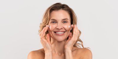 Žena si natírá krém na obličej