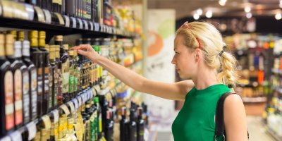 Žena si vybírá ocet v supermarketu