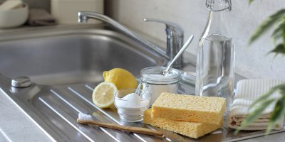 Ocet, jedlá soda, citron a houbička na dřezu