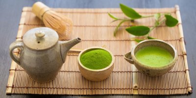 Prášek z matcha čaje a uvařený čaj matcha, konvička, a to celé na rohožce