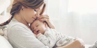 Žena má na hrudi položené spící miminko