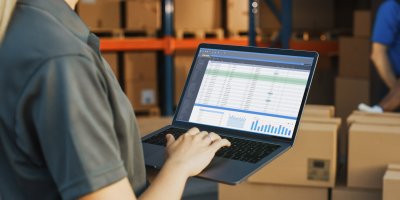 Žena s notebookem ve skladu zboží