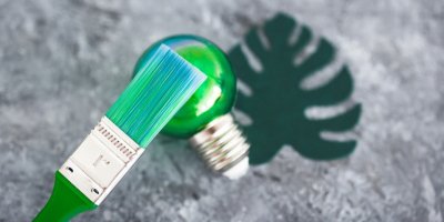 Papírový list a zelená žárovka se zelenou malbou štětcem