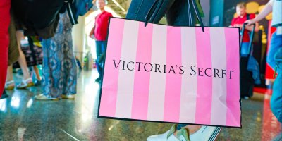 Žena drží velkou nákupní tašku z Victoria’s Secret 