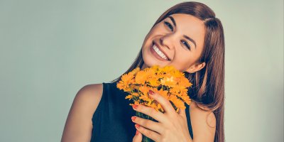 Usměvavá žena drží malou kytici z měsíčku 