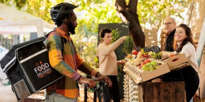 Kurýr s batohem na farmářském trhu