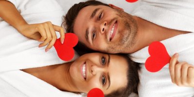 Dva lidé v županu drží srdíčka v ruce