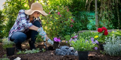 Žena sází květinu do hlíny