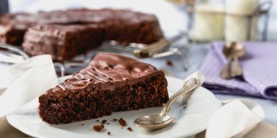 Kousek perníku politý čokoládovou polevou na talíři se lžičkou