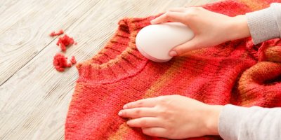 Žena používá odžmolkovač na červeném svetru