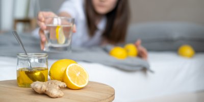 Mladá žena si bere skleničku s citronem a zázvorem