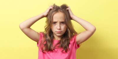 Dívka se škrábe ve vlasech