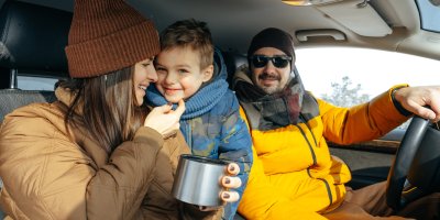 Rodina sedí v zimním oblečení v autě