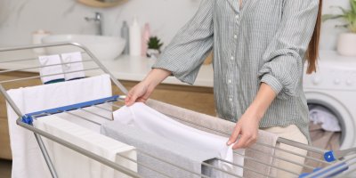 Žena věší prádlo na sušák