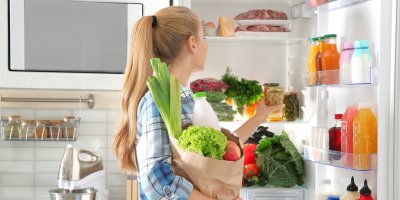 Žena ukládá potraviny do lednice