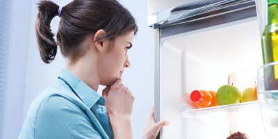 Mladá žena se dívá do lednice