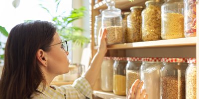 Žena si prohlíží těstoviny a luštěniny ve sklenicích