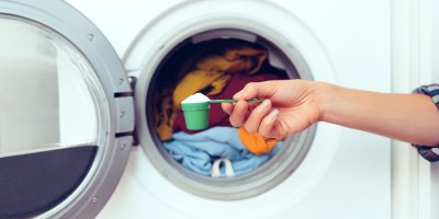 Žena vkládá prací prášek do pračky