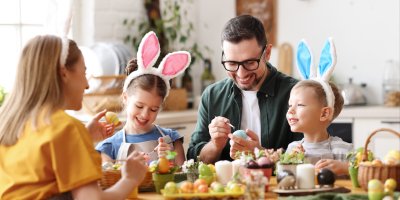 Žena, muž, dívka a chlapec malují velikonoční kraslice