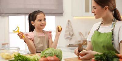 Žena s dívkou loupou brambory