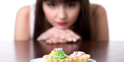 Žena se dívá zasněně na talíř se sladkostmi