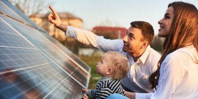 Muž, žena a dítě se dívají na solární panel