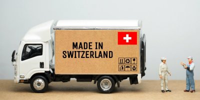 Malá dodávka s nápisem Made in Switzerland, dvě plastové figurky
