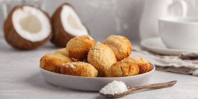 Kokosové sušenky na talířku a v pozadí kokos