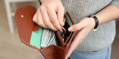 Žena vkládá drobné do peněženky