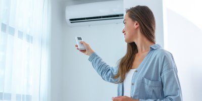 Žena zapíná klimatizaci