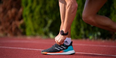 Muž si zavazuje běžecké boty